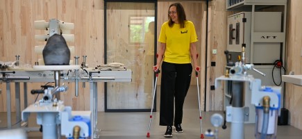 A woman with walking aids looks around the workshop.
