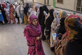 Eine Platzanweiserin in einem BISP-Zentrum in Rawalpindi, Punjab, organisiert die Warteschlange für die Registrierung. 