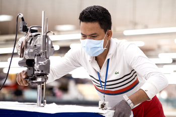 Ein Mann arbeitet im Zuschnitt in einer Textilfabrik.  Copyright: GIZ/Roman König