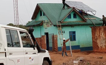 Eine Gruppe von Arbeitern installiert eine Solaranlage auf einem Hausdach.