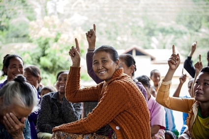 Frauen sitzen zusammen, einige von ihnen zeigen mit ihren Fingern auf. Copyright: GIZ Laos