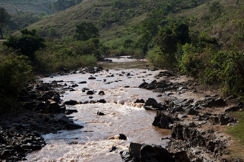 Ein steiniger Fluss umgeben von einer grünen Landschaft.