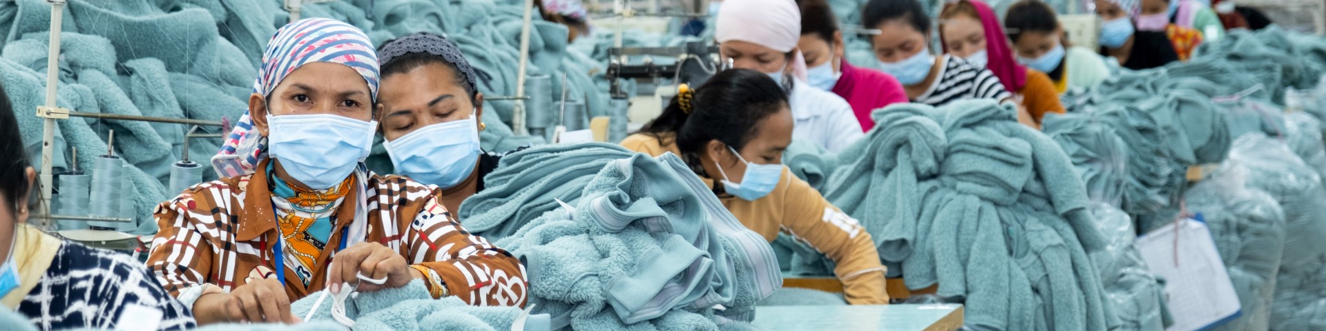 Arbeiterinnen nähen Kleidungsstücke in einer Textilfabrik. Copyright: GIZ/Roman König