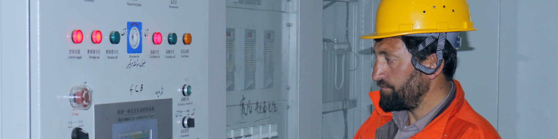Ein Techniker in Schutzkleidung inspiziert eine Stromanlage.