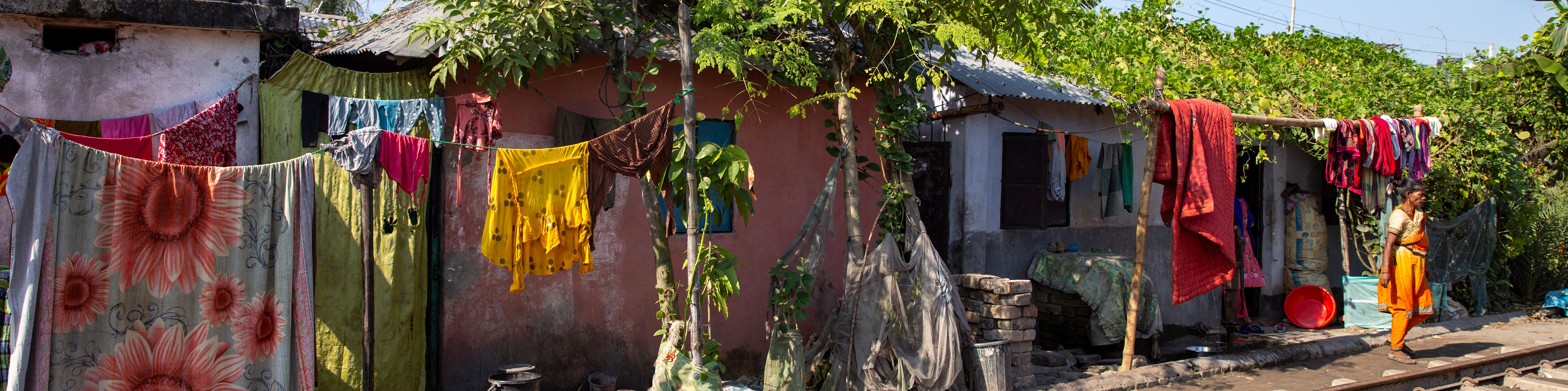 Bunte Stoffe hängen vor einem Wohnhaus. ©GIZ/Aneek Anwar
