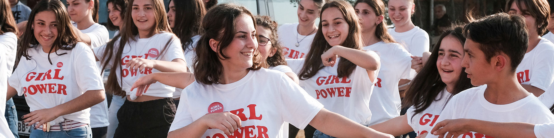 Junge Menschen tragen ein T-Shirt bedruckt mit den Worten „Girl Power“
