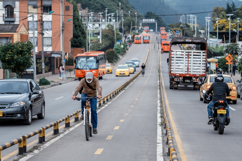 Ein Radfahrer fährt auf einem abgetrennten städtischen Radweg zwischen Autospuren. Quelle: Productora Audiovisual Mamá Sur de Colombia.