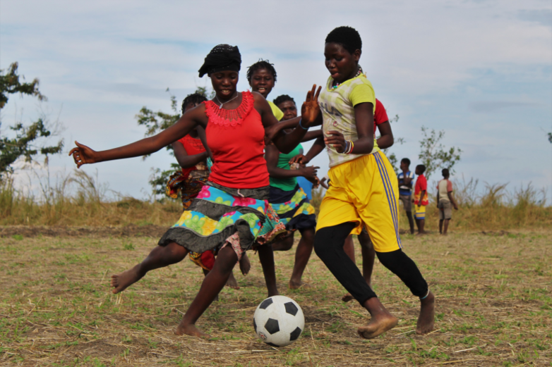 Junge Frauen spielen Fußball bei einem Turnier für Geflüchtete und aufnehmende Gemeinden.