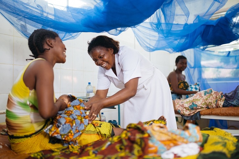 Eine Hebamme und eine Mutter freuen sich gemeinsam über die sichere Geburt eines Babys im Mtwara District Hospital.