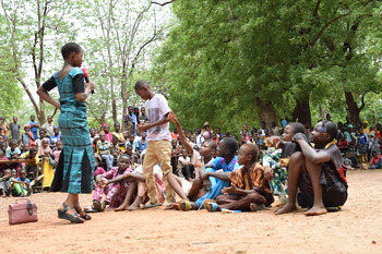 Primary school children performing a play outdoors.