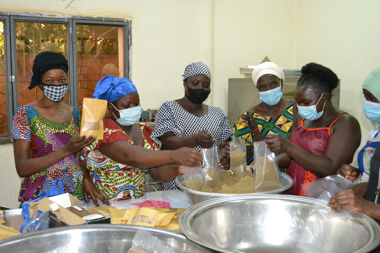 Women processing millet into lumps.