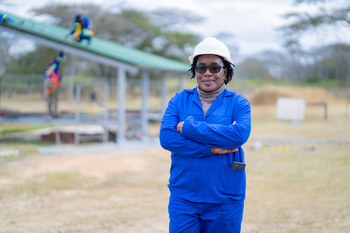 A person wearing a hard hat and blue jumpsuit.