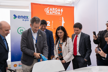 The minister of Transport and Telecommunications of Chile together with other authorities charges an electric car.