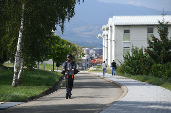A man is riding an electric scooter on a road.