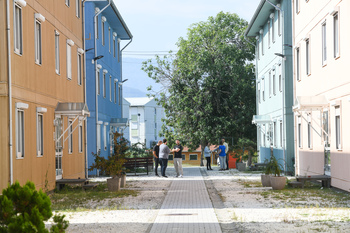 People stand together between colourful houses.