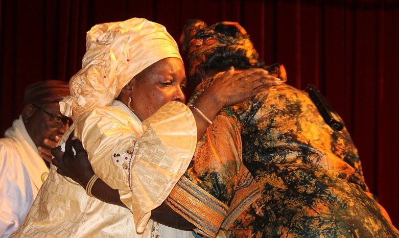 Two women embrace at the fourth public hearing of the Truth Commission. 