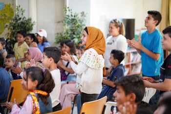 Children and young people clap during a performance by a multi-faith network in Lebanon. Copyright: GIZ/MSWR Production
