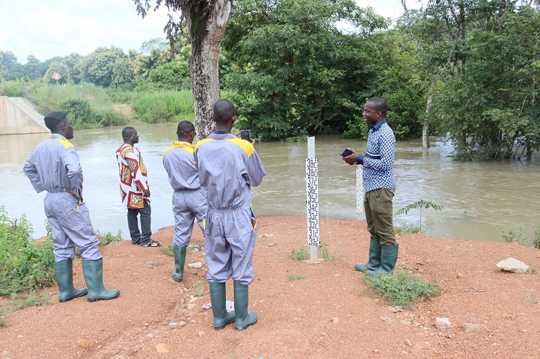 Magistrates from the supreme audit institution standing on a bank of the Niger River basin during an environmental performance audit.