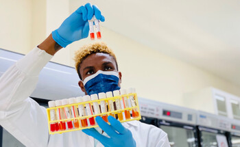 A lab worker holding and examining COVID-19 samples.