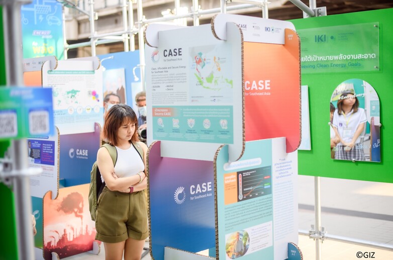 A woman looks at an information wall at an exhibition.