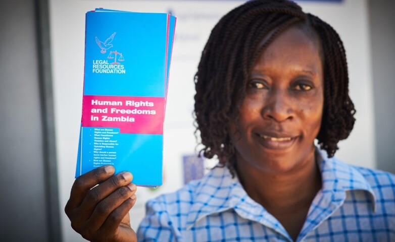 The employee of a civil society organisation supported by the project showing some information material