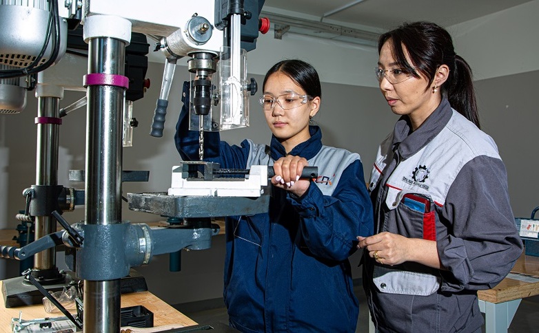 Two women work on a machine as part of a TVET course in Mongolia.