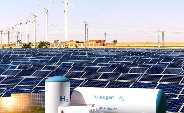 Solarparkanlage in Kabertène, Adrar, hinter der sich eine Windkraftanlage befindet