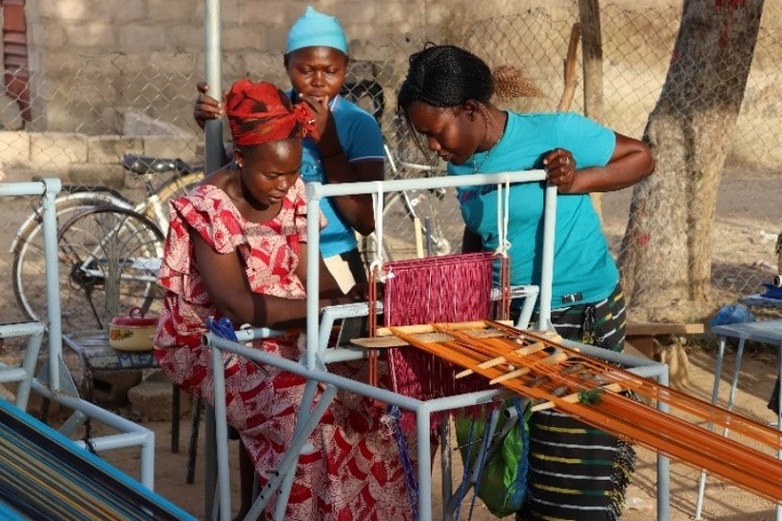Women engaged in traditional weaving on a loom.
