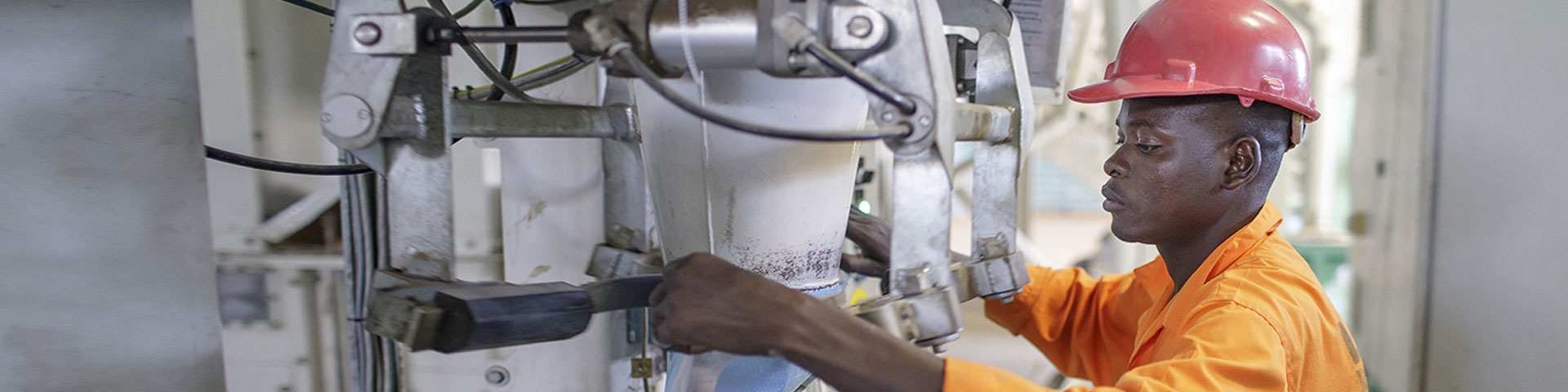 An industrial worker operating a machine.