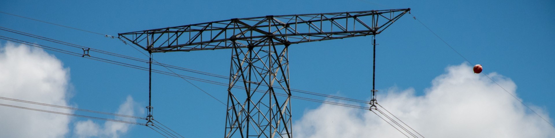 The mast of a high-voltage power line against a blue sky. Copyright: GIZ