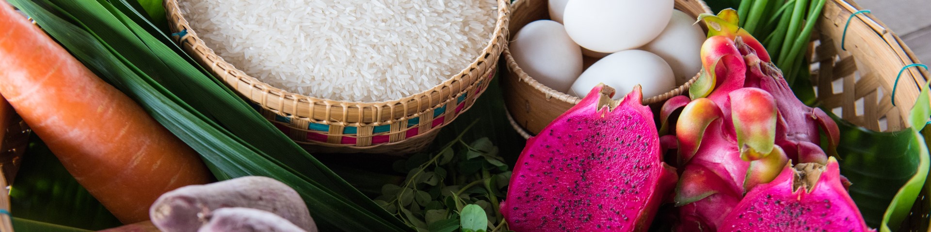 The picture shows a basket with food like rice, eggs and dragon fruit.