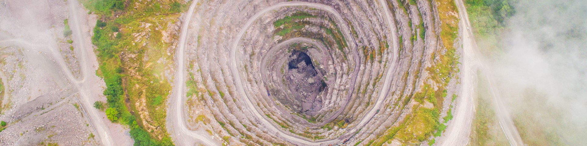 An aerial image of a rocky, spiral-shaped opening in the ground.