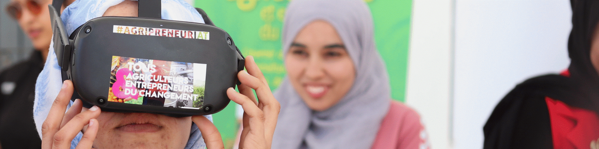 A woman with a hijab wears VR glasses.