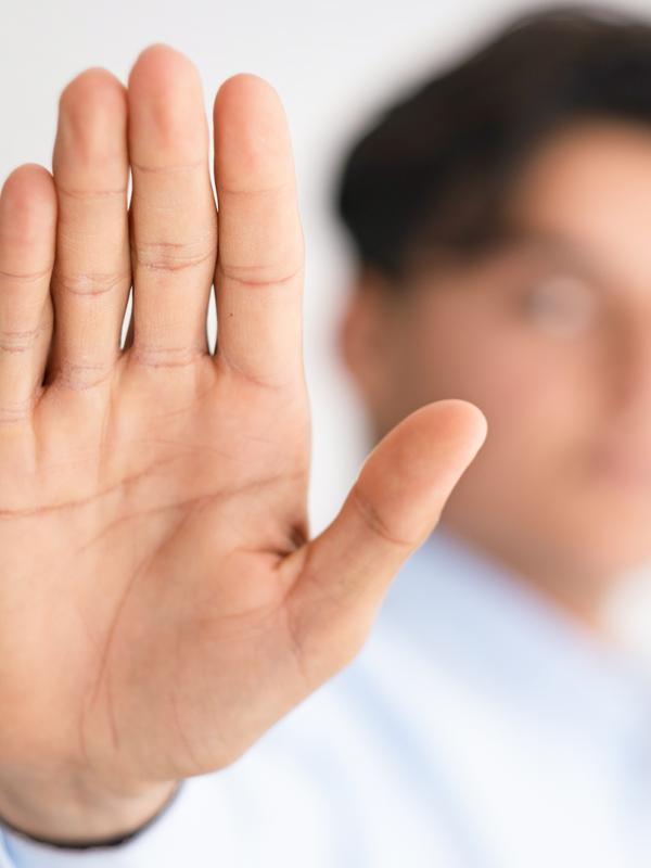 Eine Person hält der Kamera die flache Handfläche entgegen.