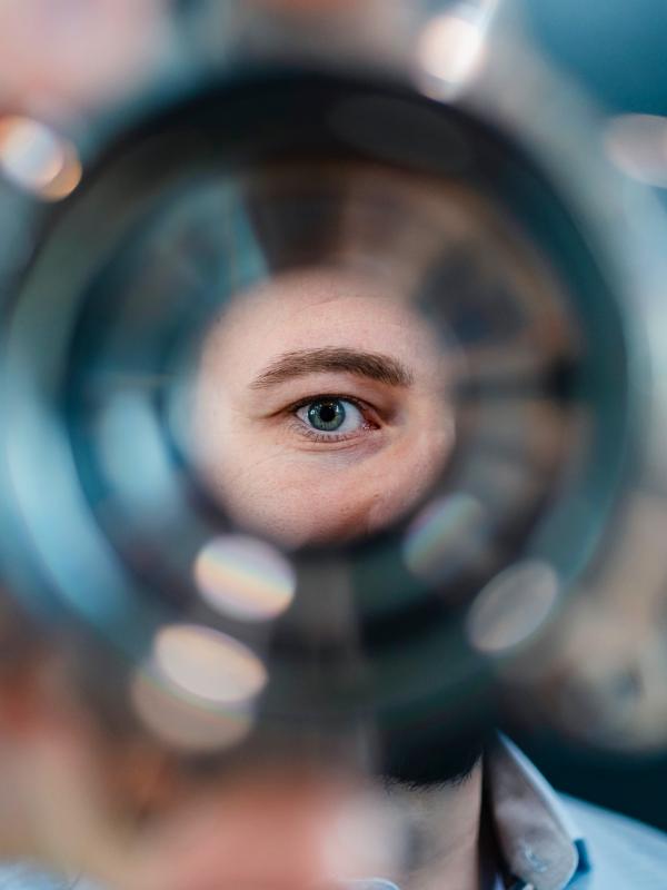 Mann blickt durch ein Werkstück