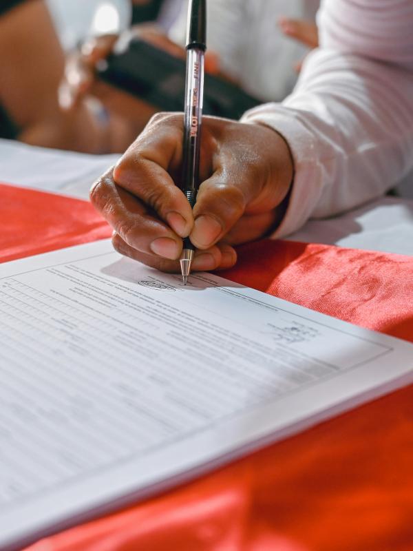 Nahaufnahme einer Hand, die ein Dokument unterschreibt