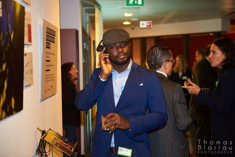 Ein Mann hält sich einen Kopfhörer ans Ohr