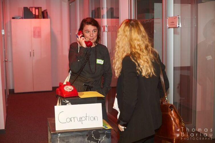 Eine Frau hält den Hörer eines roten alten Telefons in der Hand