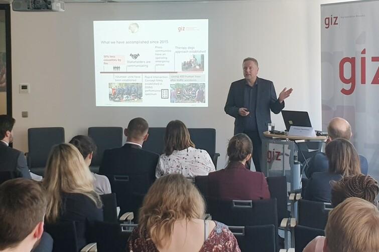 Ein Mann steht vor einem Publikum