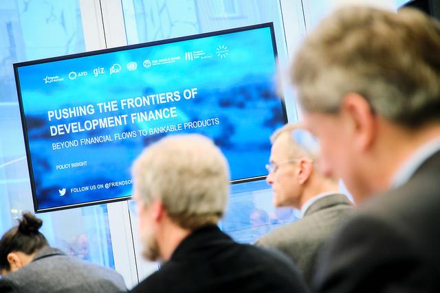 Bildschirm mit der Aufschrift "Pushing the frontiers of development Finance"