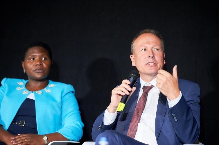 Mann sitzt rechts von einer Frau und hält ein Mikrofon in der Hand