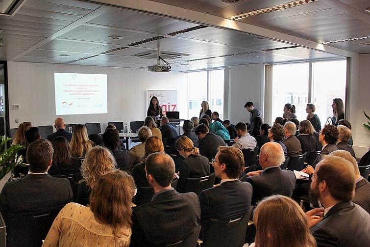 Publikum schaut nach vorne auf einen Bildschirm