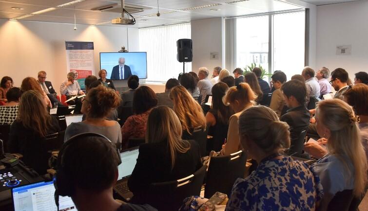 Publikum schaut nach vorne auf einen Bildschirm