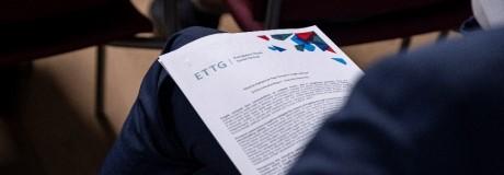 Mehrere Blatt Papiere liegen auf einem Bein