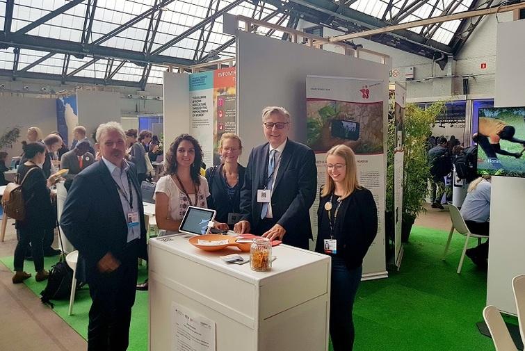 Personen stehen um einen Stand herum