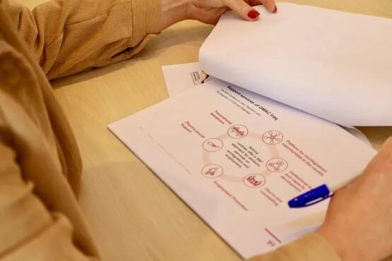 Hands holding paperwork lying on a desk