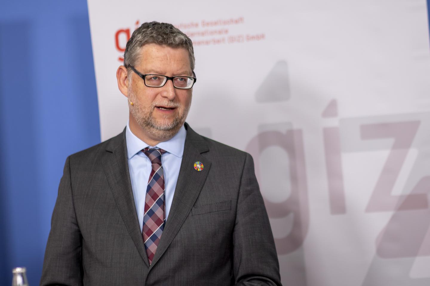 Thorsten Schäfer-Gümbel während einer Rede vor einem GIZ-Banner.