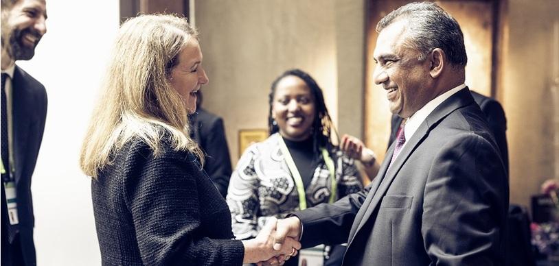 A man shakes a woman's hand.