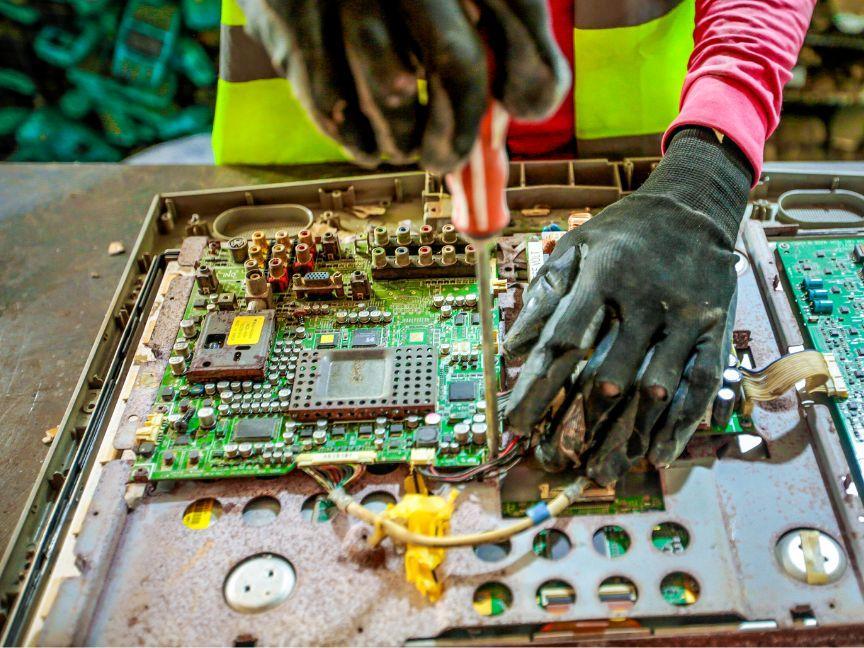 Alte Platinen werden aus einem Gehäuse rausgeschraubt