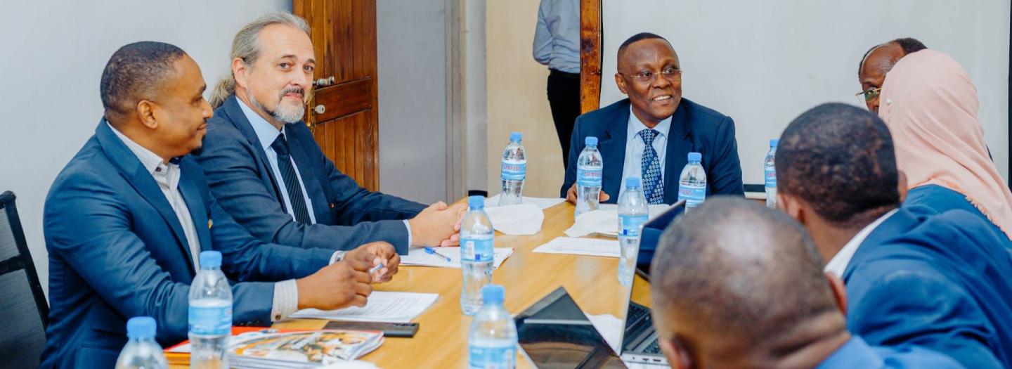 Menschen aus verschiedenen Ländern sitzen gemeinsam an einem Konferenztisch.